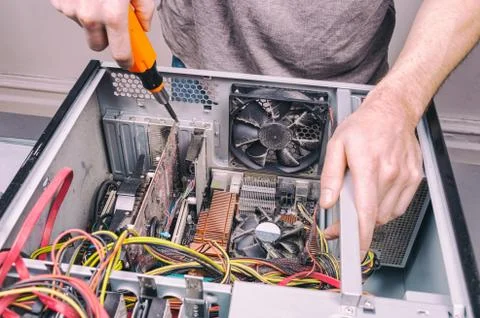 Man fixing an old desktop computer using a screwdriver Stock Photos