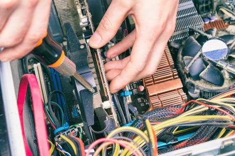 Man fixing an old desktop computer using a screwdriver Stock Photos