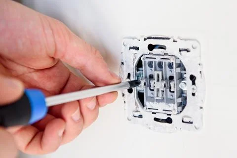 Man fixing a socket with a screwdriver Stock Photos