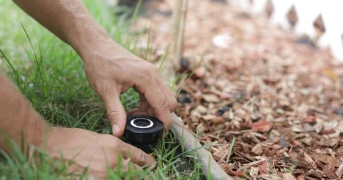Man fixing Sprinkler Head in backyard Stock Footage 120670418