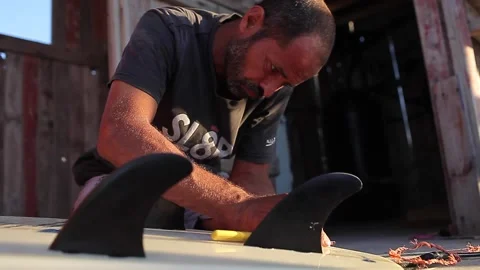 Man fixing the surfboard Stock Footage 148621012