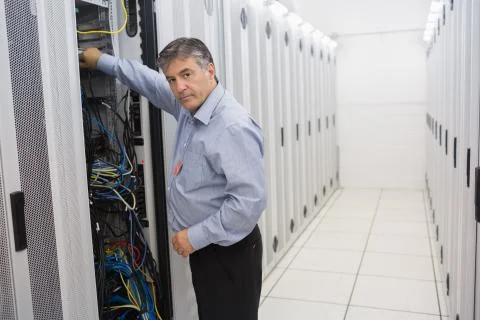 Man fixing wires of servers Stock Photos