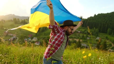 A man with the flag of Ukraine on the background of mountains. Stock Footage 171242007