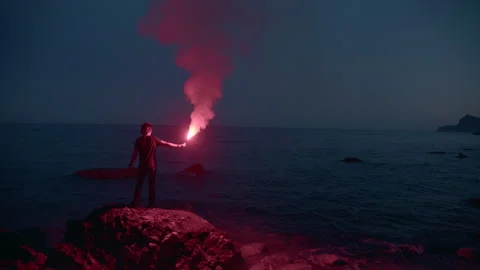  Man with flare going off at dusk on the beach Stock Footage 161466248