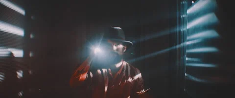 Man flashing flashlight towards camera in lights of shutters Stock Footage 203565641