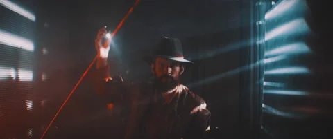 Man flashing flashlight towards camera in lights of shutters Stock Footage 203566463