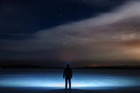 A man with a flashlight on his head is standing and looking at the beautiful  Stock Photos