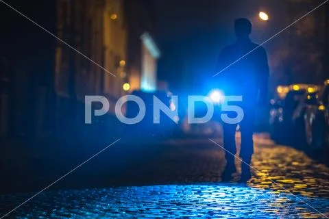 The man with a flashlight inspect the road. Evening night time Stock Photos
