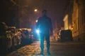 The man with a flashlight inspect the street. Evening night time Photo