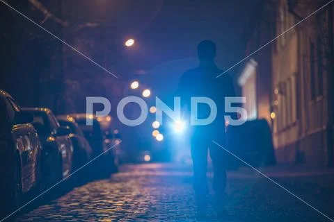 The man with a flashlight inspect the street. Evening night time Stock Photos