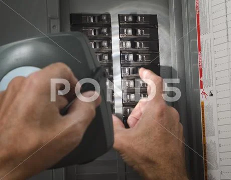 Man With Flashlight At Residential Circuit Breaker Panel