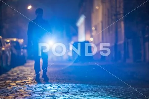 The man with a flashlight stand on the road. Evening night time Stock Photos