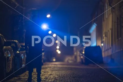 The man with a flashlight stand on the street. Evening night time Stock Photos