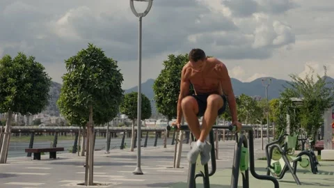 Man flexing abs on parallel bars in gym. Working on his core. Full length shot Video stock 218478058