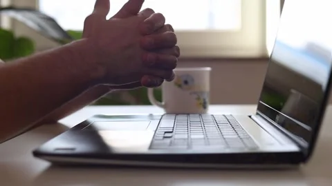 Man flexing his hands while sitting at a laptop Video stock 244599130