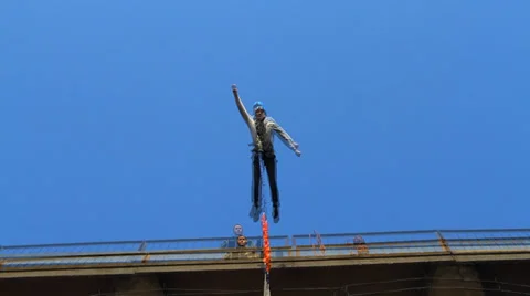 Man flies off a bridge into Superman pose Stock Footage 37033647