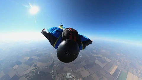 A man flies in a wingsuit suit in a clear sky in sunny weather Vidéo 195500512