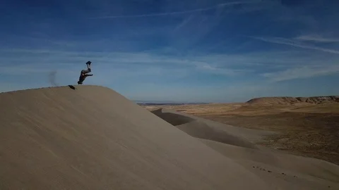 Man Flipping and Falling Down A Sand Dune in the Desert Drone Shot Stock Footage 99070409