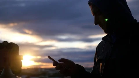 Man flipping phone on sunset background and sun rays. slow motion, 1920x1080 Stock Footage 78973418