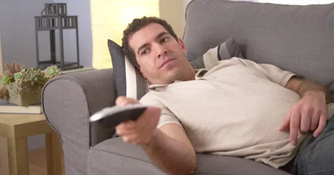 Man flipping through channels on couch Stock Footage 42582820