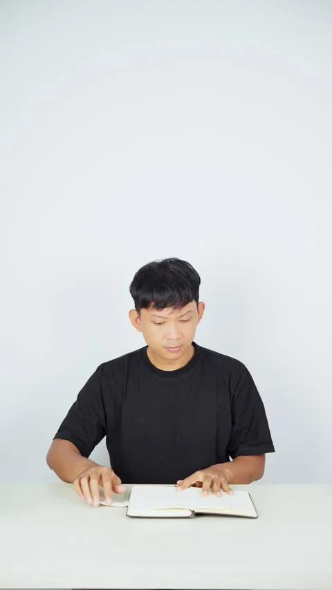 Man Flipping Through Notebook Pages on White Background Stock-Footage 347104957