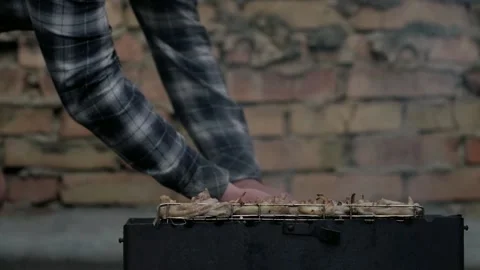Man flips barbecue grill over the fire Stock Footage 195092242