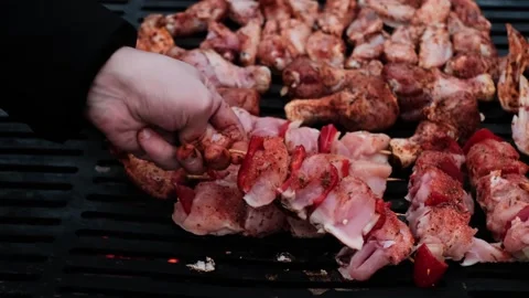 Man flips meat while organizing a barbecue and picnic with loved ones, outdoor g Stock Footage 280186550