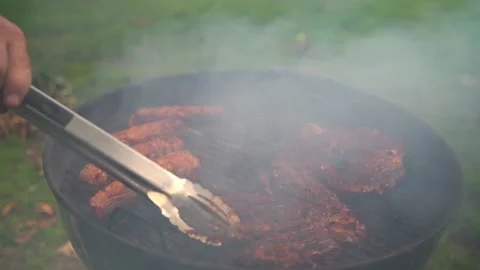 Man flips over steaks Stock Footage 158183768