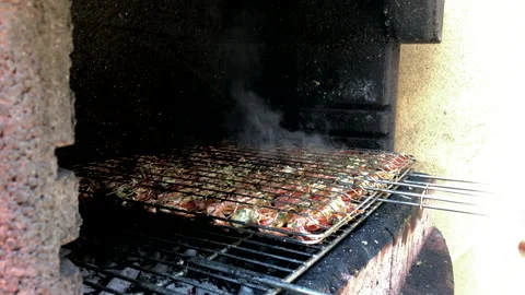 Man flips prawns on the barbecue Stock Footage 131051384