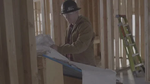 A man flips through construction plans Stock Footage 102125329