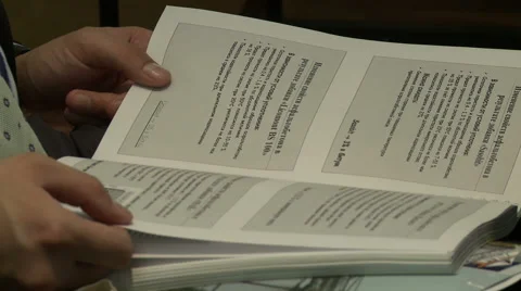 Man flips through handbook at conference Stock Footage 56572559