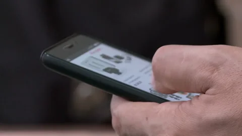 The man flips through his fingers on the touchscreen phone Video stock 91892640
