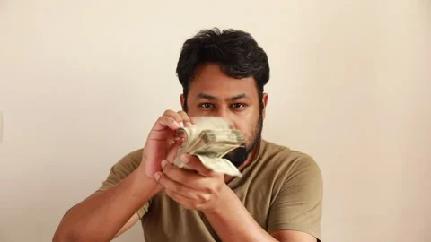 Man flips through Indian Rupee bills while giving various facial expressions Stock Footage 166504688