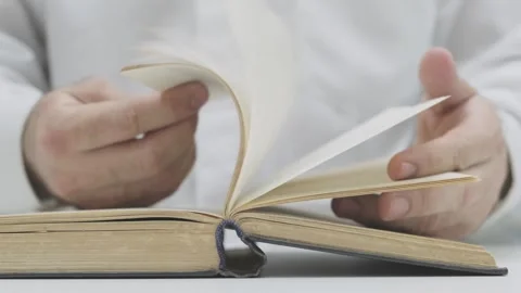 Man flips through pages of old book 스톡 동영상 271070787