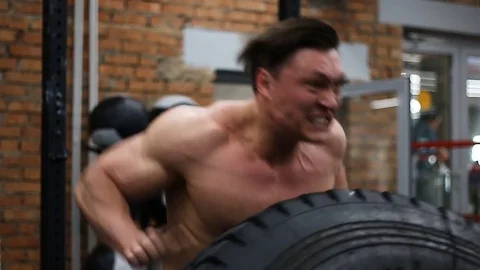 A man flips a tire during his cross fir training. 스톡 동영상 76969022