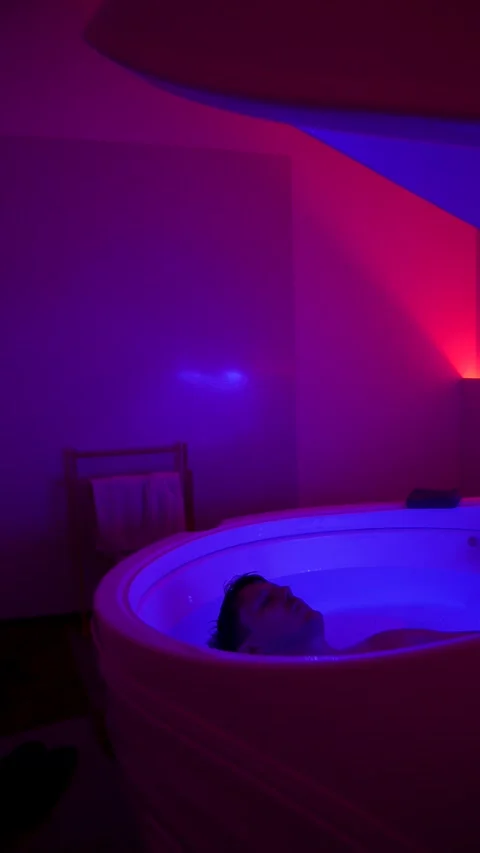Man float in hyper-saline sensory deprivation tank for deep relaxation Stock Footage 331659928