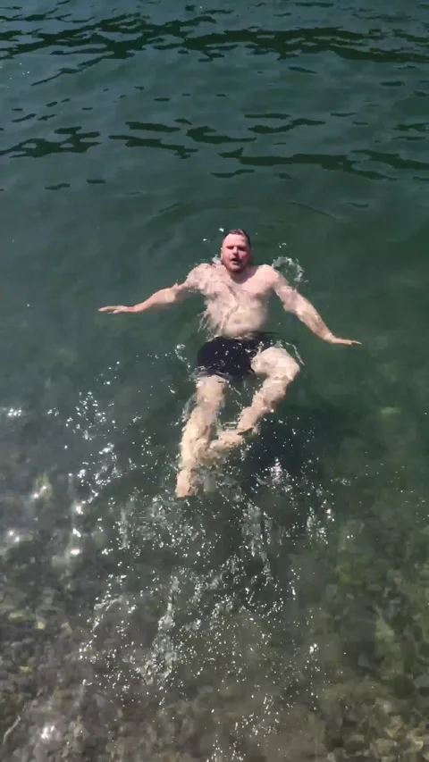 Man floating on back in mountain lake Stock Footage 170268214