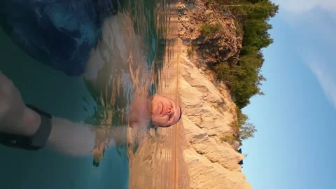 A man is floating on his back in front of a landscape. The picturesque land.. Stock Footage 249105005