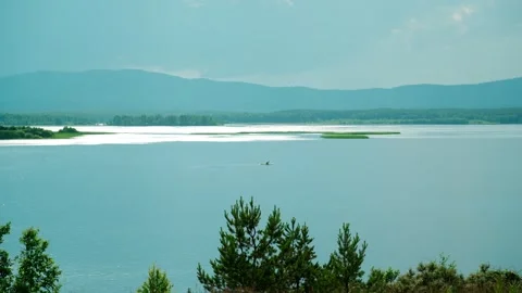 A man floating on a lake on a SUP board on a sunny summer day. 库存影片 337564726