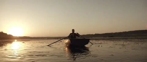A man is floating on a river on a boat Stock Footage 141885907