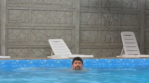 Man floating on water in swimming pool. 스톡 동영상 64987572