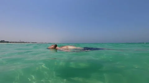 Man floating on water in tranquility Stock Footage 132253991