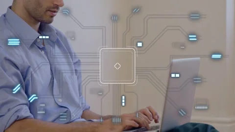 Man on floor typing laptop and creating chip graphic growing with blue glow Stock Footage 335739596