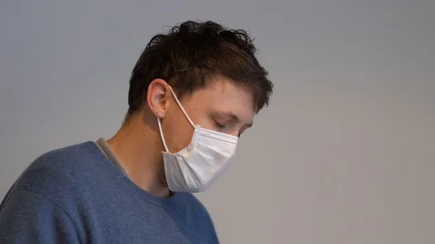 A man with the flu virus coughing while wearing a surgical mask Stock Footage 123893830