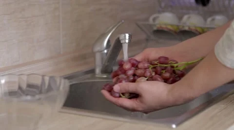 A man is flushing pink vine under the steam of cold water Stock Footage 54330343