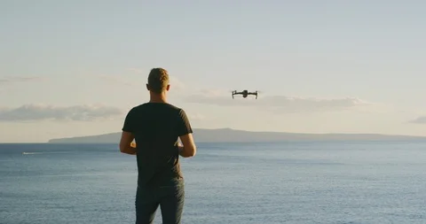 Man flying a drone over the ocean Stock Footage 120197286