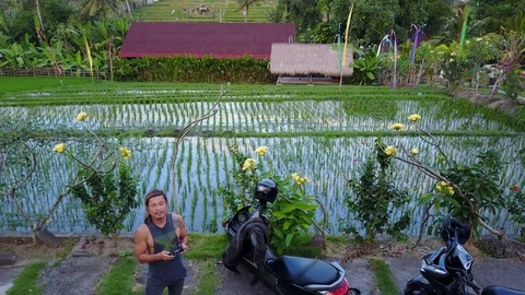 Man Flying Drone Shooting 4K Aerial Footage of Canggu Bali Rice Fields Stock Footage 101785700
