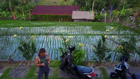 Man Flying Drone Shooting 4K Aerial Footage of Canggu Bali Rice Fields Video stock 101785869