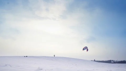 A man with flying kite on snowy hill with beautiful blue sky backgroung Stock Footage 88096356