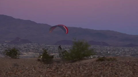 A man flying a para-plane at low level over the desert Stock Footage 322180577